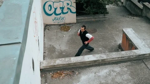 The guy is training parkour. Jumps on the railing on a cold autumn day. Does a Video stock 120241085