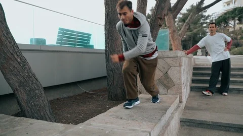 The guy is training parkour. Jumps on the railing on a cold autumn day. Does a Video stock 120423084