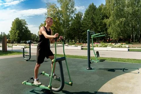 The guy trains his muscles doing exercises on a power simulator showing Fotos de archivo