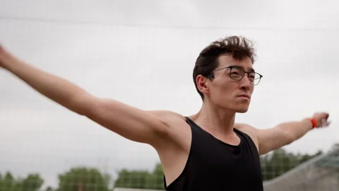 The guy trains at the stadium in a black T-shirt and glasses Stock Footage 255671778