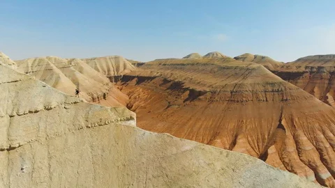 Guy with a travel backpack rises uphill walking along the ridge Stock Footage 106205081