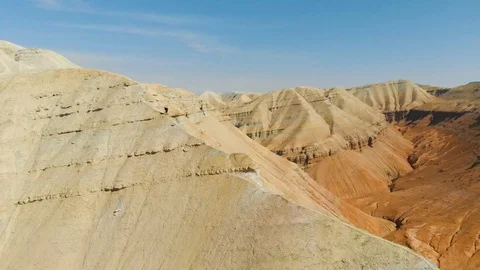 Guy with a travel backpack rises uphill walking along the ridge Stock Footage 108867599