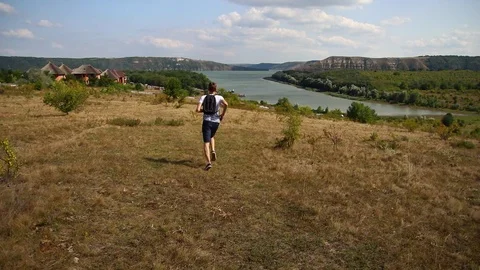Guy traveling to the canyon, running the fieldlake, forest, Stock Footage 94540407