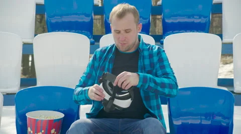 A guy on tribune putting on VR glasses Stock Footage 63841711