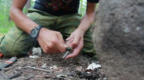 Guy tries to light a fire with the help of silicon Stock Footage 65445866