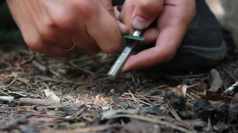 Guy tries to light a fire with the help of silicon close up Stock Footage 65446148
