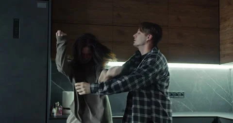 A guy tries to physically restrain his girlfriend during a couple quarrel in the Stock Footage 305775176