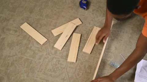 A guy is trying to assemble a rack without instructions, top view Stock Footage 287161458