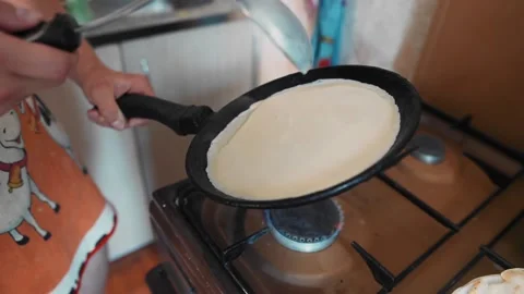 The guy turns the pan and distributes the dough evenly over the area Vídeo Stock 134424444