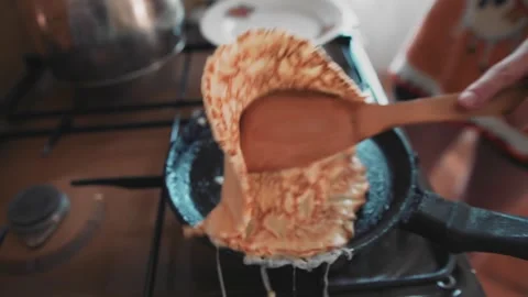 The guy turns a pancake on a hot pan. Close up. Cooking pancakes at home Stock Footage 134424408