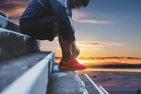 A Guy Tying Running Shoe, Preparing for Running in the Morning Stock Photos