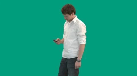 Guy types on his mobile phone - green screen - pre keyed Stock Footage 8647659