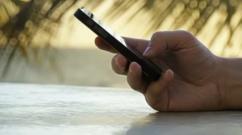 Guy is typing on a cell phone on the beach Stock Footage 52610003