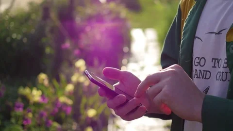 The guy is typing on smartphone outdoors Stock Footage
