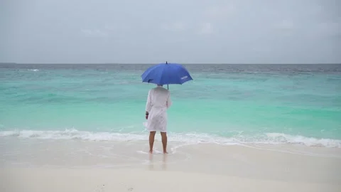 A guy with an umbrella stands on the beach Stock Footage 146751984