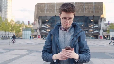 The guy uses his gadget and checks messages Видео 80168534