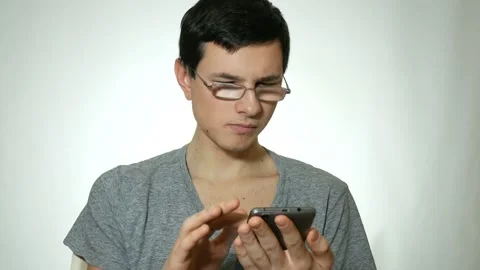 Guy uses a smartphone 스톡 동영상 91003262