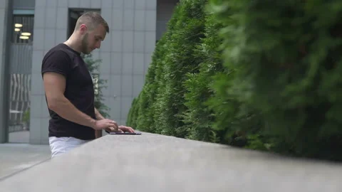 The guy uses the tablet on the street Stock Footage 113405240
