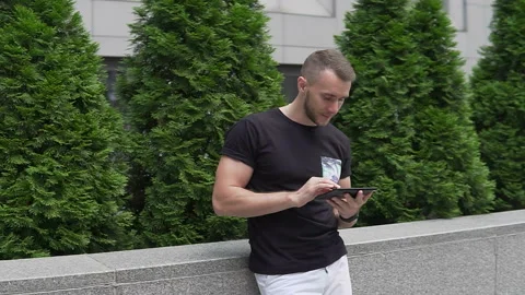 The guy uses the tablet on the street Stock-Footage 113405309