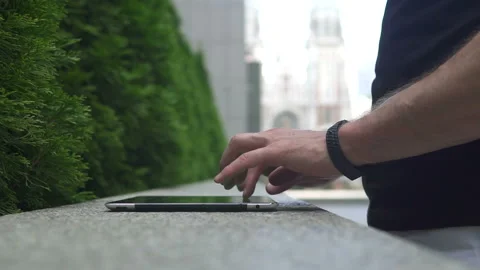 The guy uses the tablet on the street, only hands are visible Stock-Footage 113405221