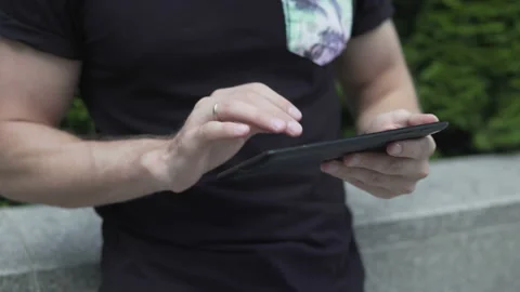 The guy uses the tablet on the street, only hands are visible Stock-Footage 113405552