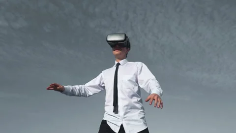 Guy uses a virtual reality glasses on the backfound of sky Stock Footage 96511943