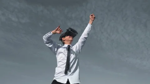 Guy uses a virtual reality glasses on the backfound of sky Stock Footage 96512843