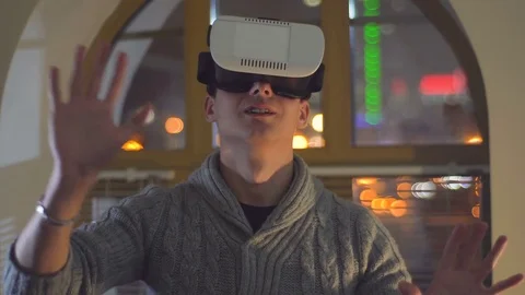 Guy uses VR goggles in the background of city lights Stock Footage 72291971