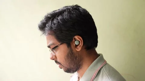 A guy using Google pixel buds listen to music in side view Stock Footage 159639411