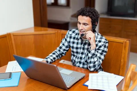 Guy using headset and laptop computer, chatting on Internet Stock Photos