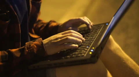 Guy using his laptop at nigth on the street Stock Footage 67501596