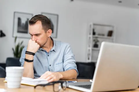 A guy is using laptop sitting at the desk 스톡 사진