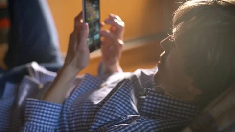 Guy using a mobile phone in the bedroom at home Video stock 72826157