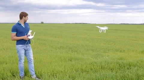 Guy using remote control to film aerial video with drone mounted camera, robot Stock Footage 64078521