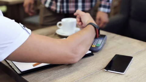 A guy using a smart clock pays in a restaurant Vídeo Stock 90952103