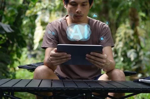 Guy Using Tablet in Nature with AI Concept and Digital Graphics Stock Photos