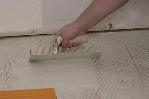 Guy using a tool to smooth concrete over subflooring Stock Photos