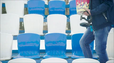 A guy in VR glasses and popcorn sitting on the tribune Stock Footage 63839221