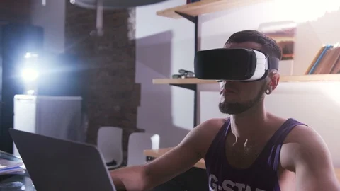 Guy in VR glasses sitting at table and looking straight. Portrait of young man Stock Footage 98178035