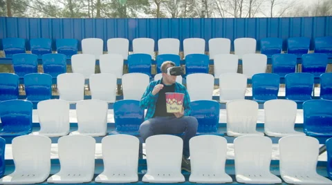 Guy in VR glasses talking the phone at the stadium Stock Footage 63841920