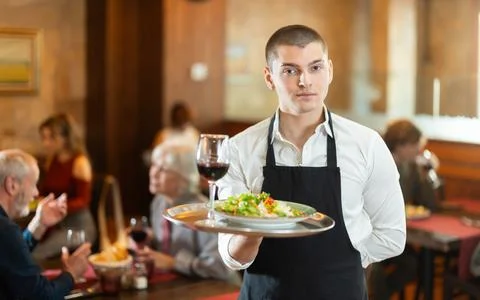 Guy waiter with tray in cafe hall Stock Photos