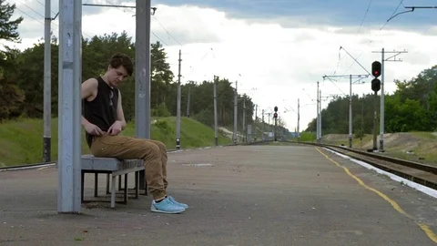A guy is waiting at the train station Stock Footage 76626194