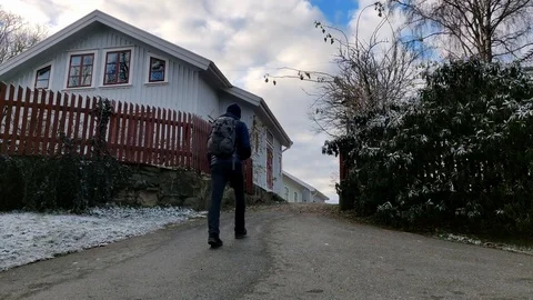 Guy Waking up a Hill in Residential Area Winter Time Stock Footage 99534302
