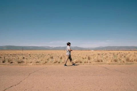 Guy waking on a road Stock Photos