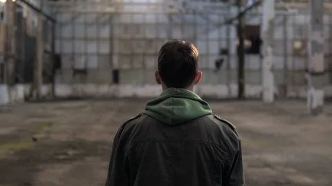 The guy is walking in an abandoned building and turns around. Stock Footage 119547320