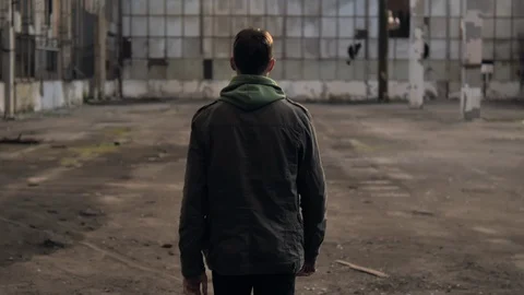 The guy is walking in an abandoned building and turns around Vídeo Stock 119547442