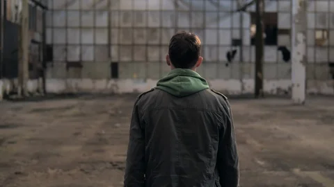 The guy is walking in an abandoned building and turns around Vídeo Stock 119547475