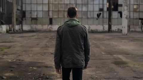 The guy is walking in an abandoned building and turns around Vídeo Stock 119547497