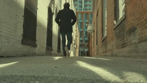 Guy walking in alley Stock Footage 150006997