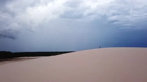 Guy walking alone in dunes of Lencois Maranhenses Stock Footage 168397977